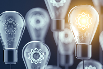 A lightbulb glows among many unlit bulbs